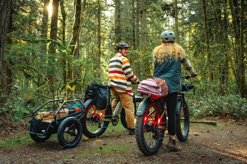 cyclists with bicycles and gear in a forest setting