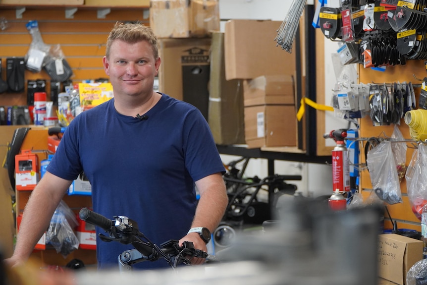 Sam smiles in a bike shop.