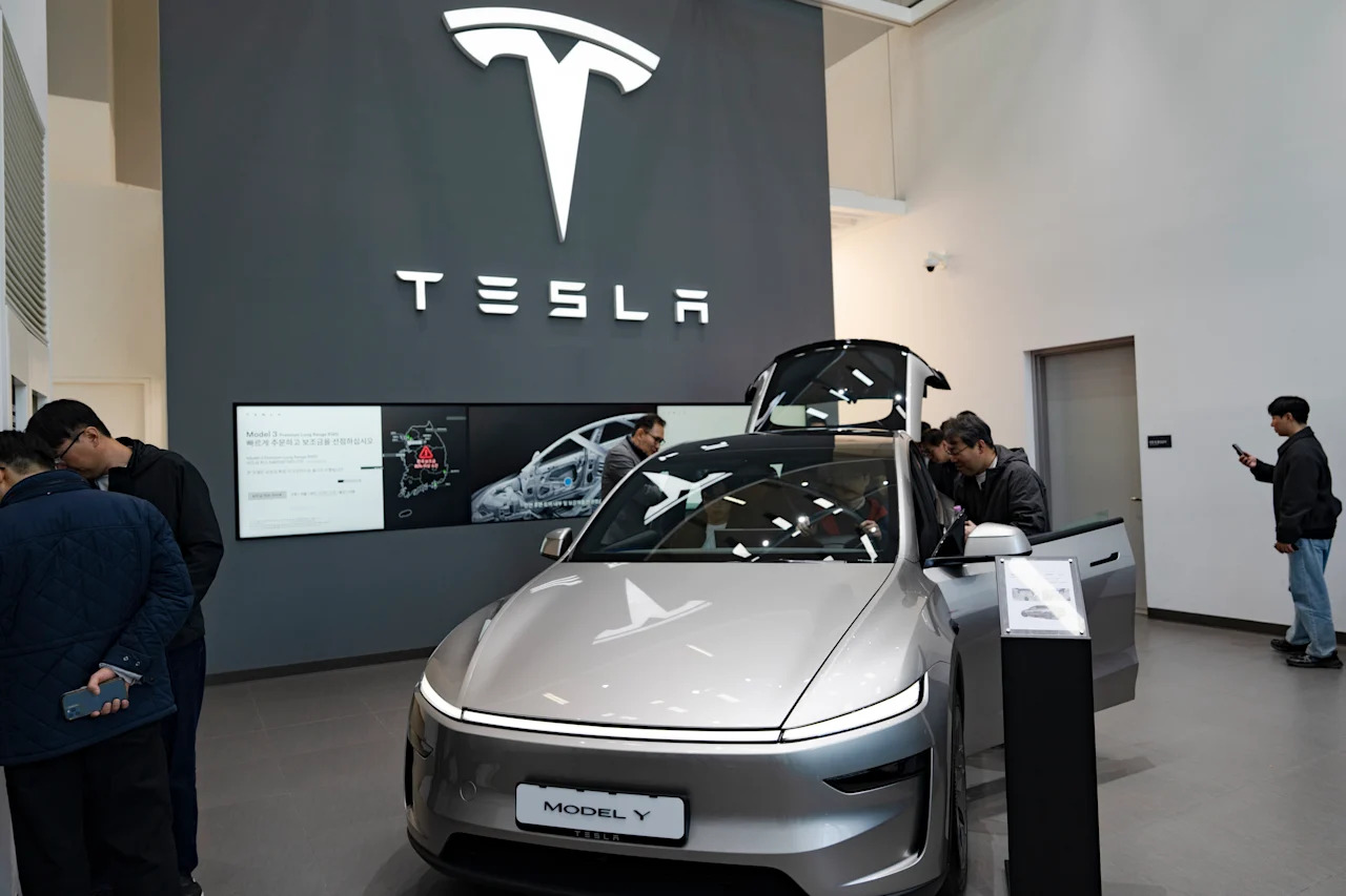 Visitors look at the new Tesla Model Y L (Long Wheelbase) at a showroom in Yeouido, Seoul, on April 8, 2026. Tesla Korea begins sales of the three-row, six-seat electric SUV, with orders reportedly reaching approximately 60,000 units on its official website. (Photo by Chris Jung/NurPhoto via Getty Images)