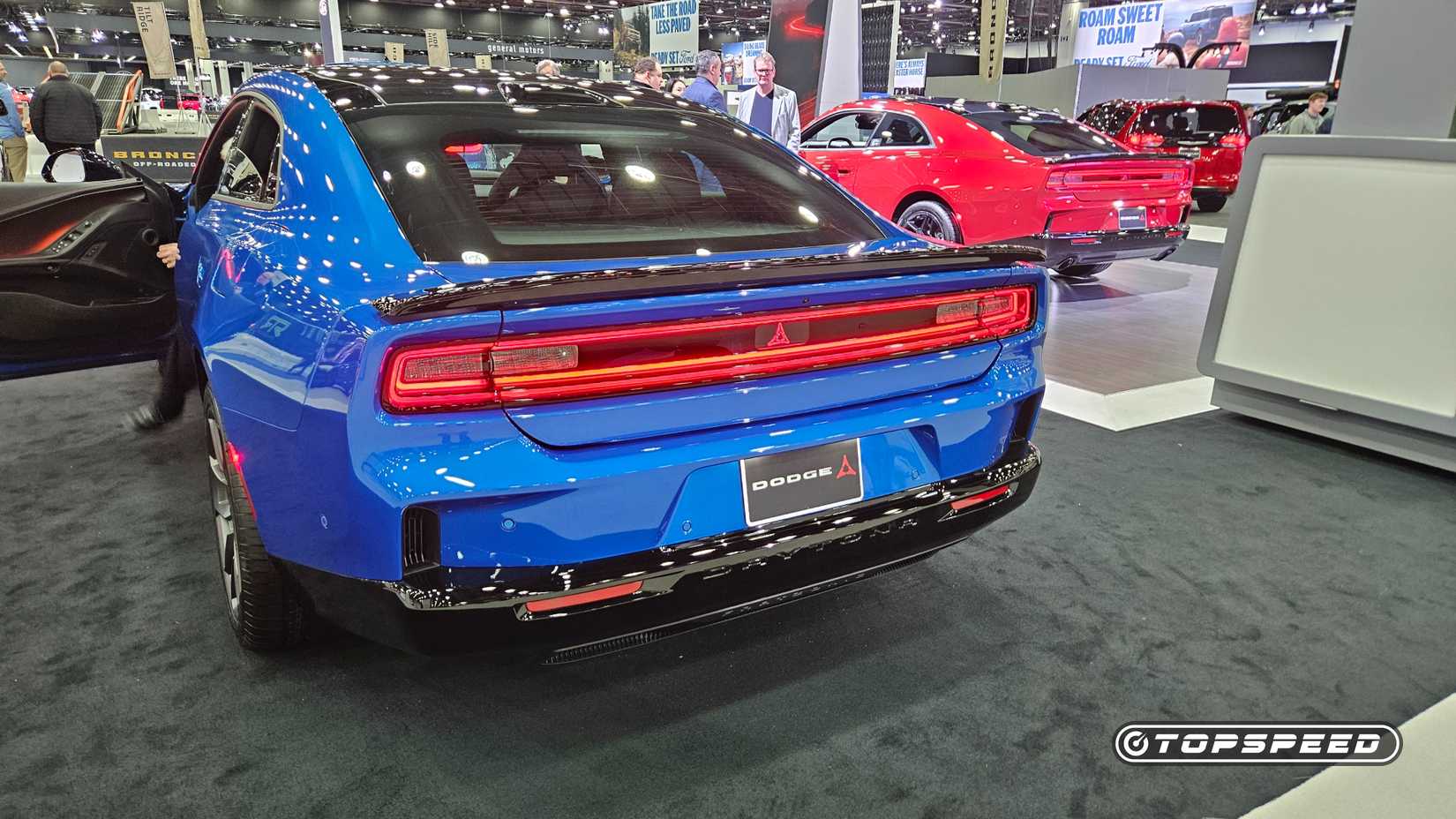 dodge-daytona-charge-ev-next-to-red-charger-ice-6pack-2026-detautoshow-2