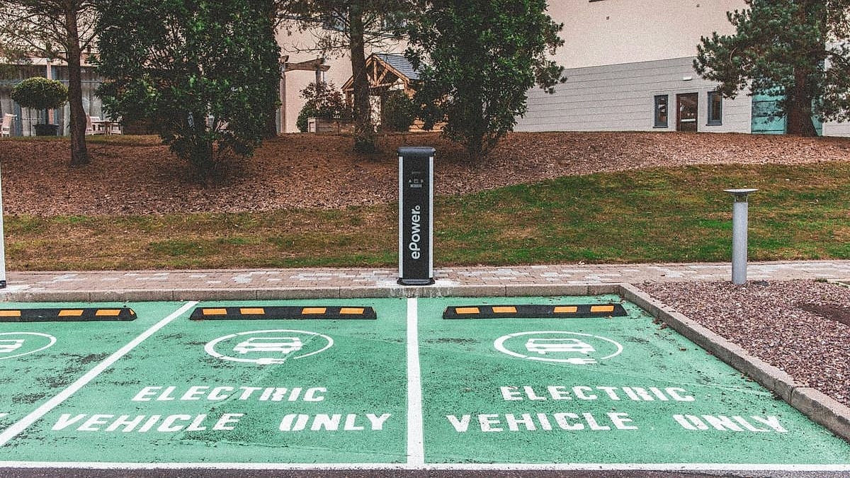 Two green-painted electric vehicle only parking spaces with ePower charging station between them in an outdoor lot
