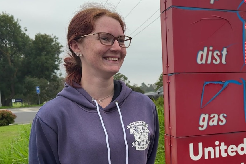 A TAFE student Trinity Hood smiling at a petrol station