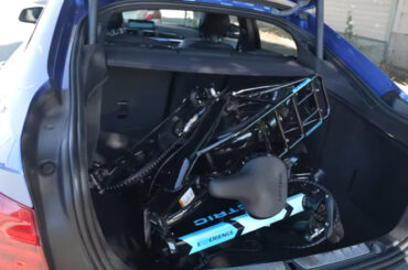 Folded up Lectric XP 3.0 in the open trunk of a car