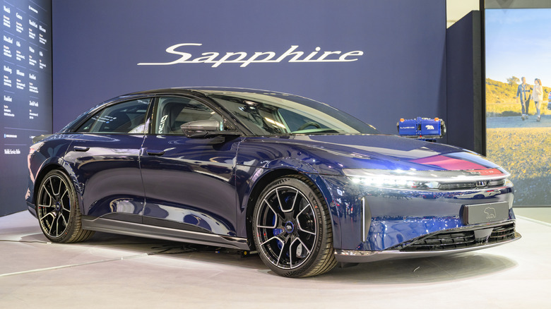A dark blue Lucid Air Sapphire EV sedan parked on a Lucid Sapphire indoor display