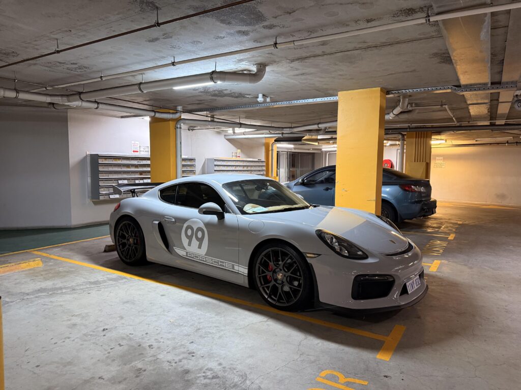 [Porsche Cayman 981 GT4] at building's visitor parking