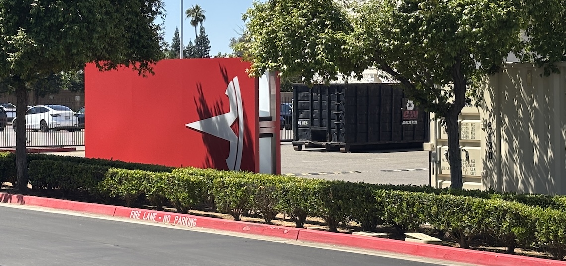 tesla t sign sitting sideways in a parking lot