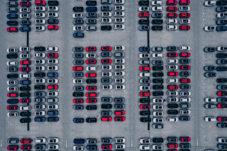 An aerial view of a lot full of new cars.