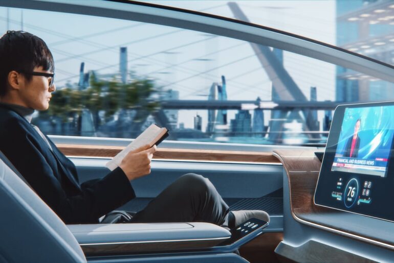A person reading book in an autonomous car.