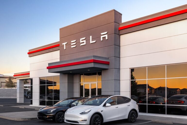 Tesla dealership with two cars parked in front of the building.