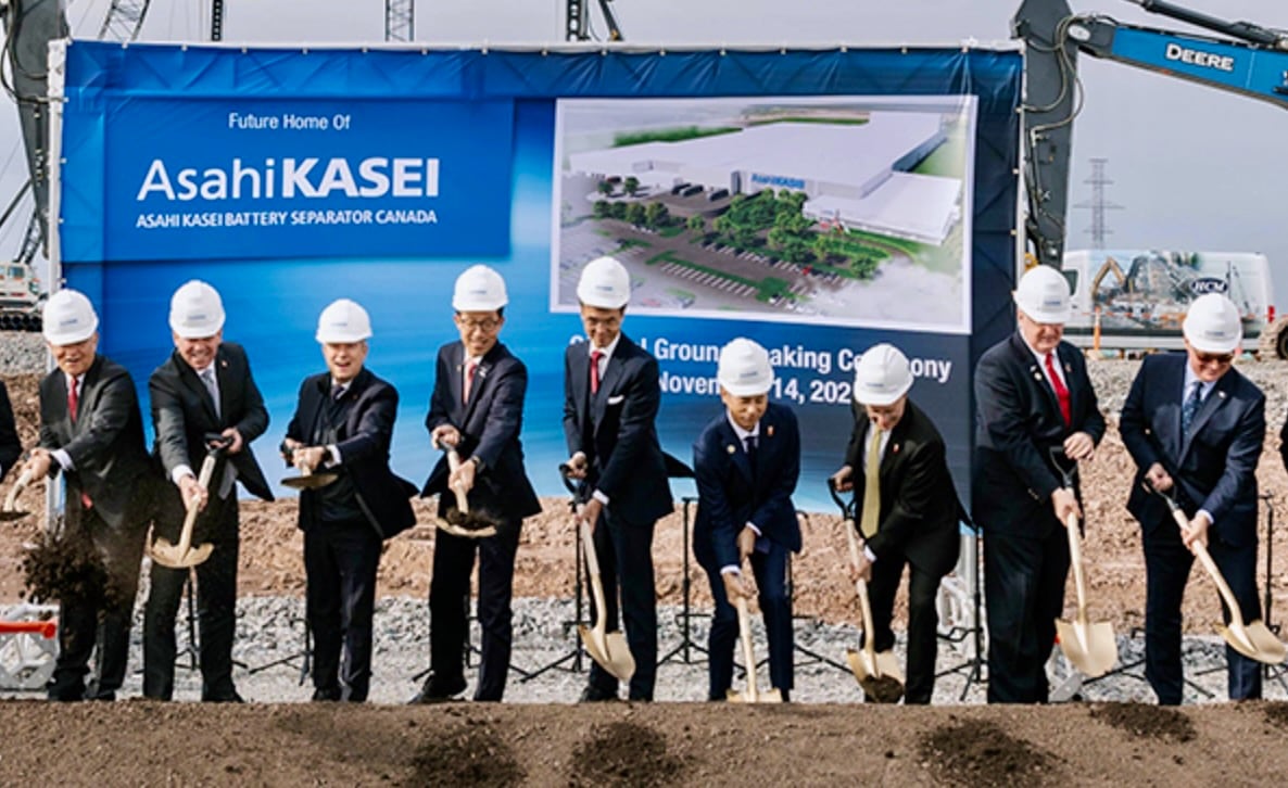Men in suits pose with shovels.
