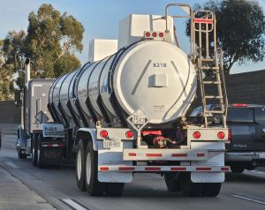Semi-trailer tank truck hauling ferric chloride with hazmat placard 2582