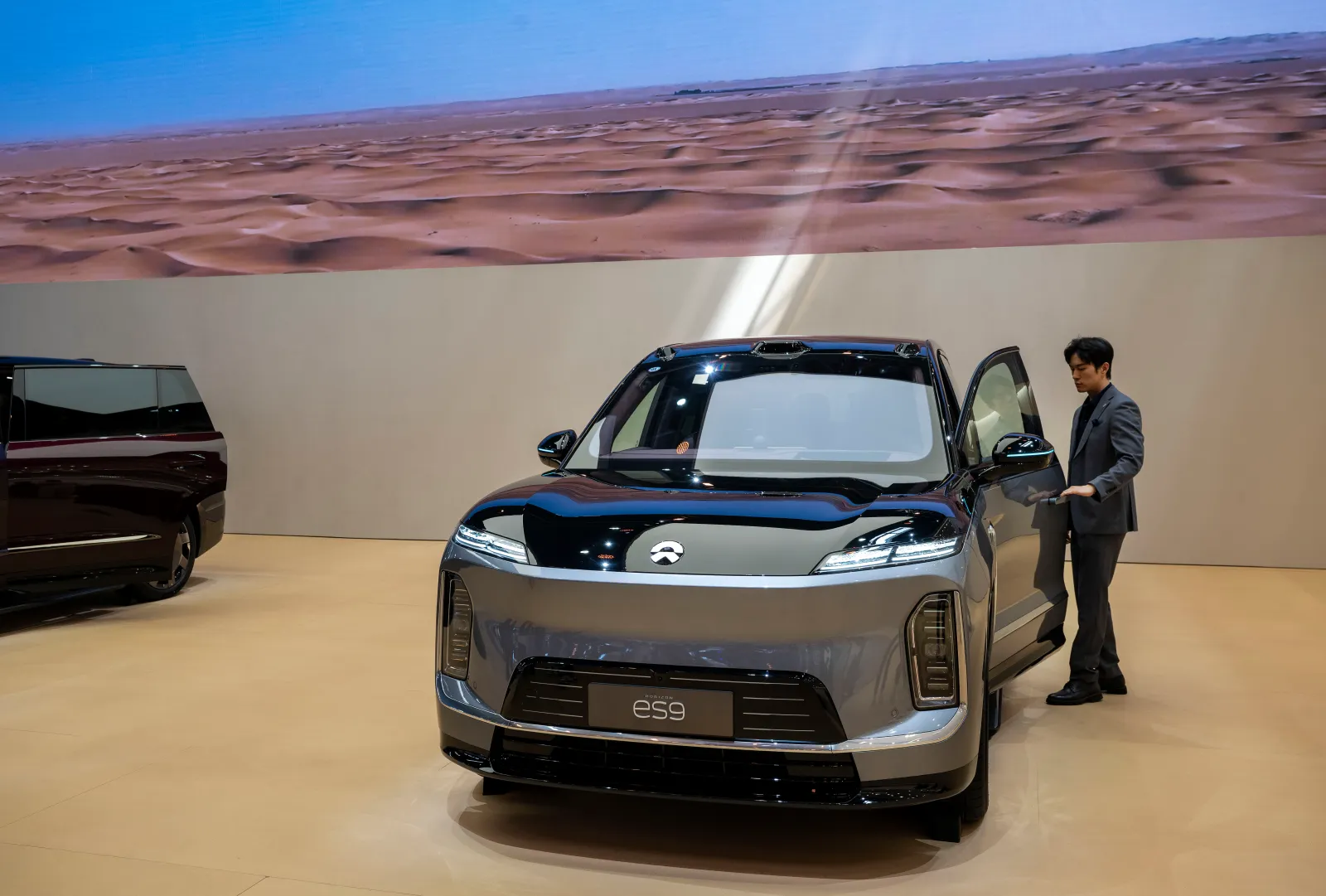 A sales person opens the door of an ES9 electric SUV made by Chinese automaker NIO at the Beijing International Auto Exhibition on April 25, 2026.