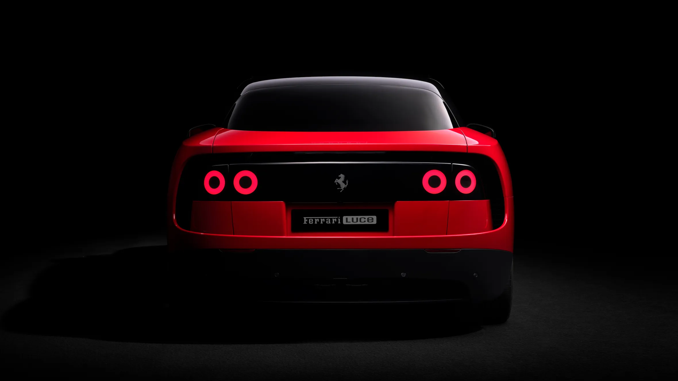 The rear of a red Ferrari Luce against a black background, with its circular taillights glowing red.