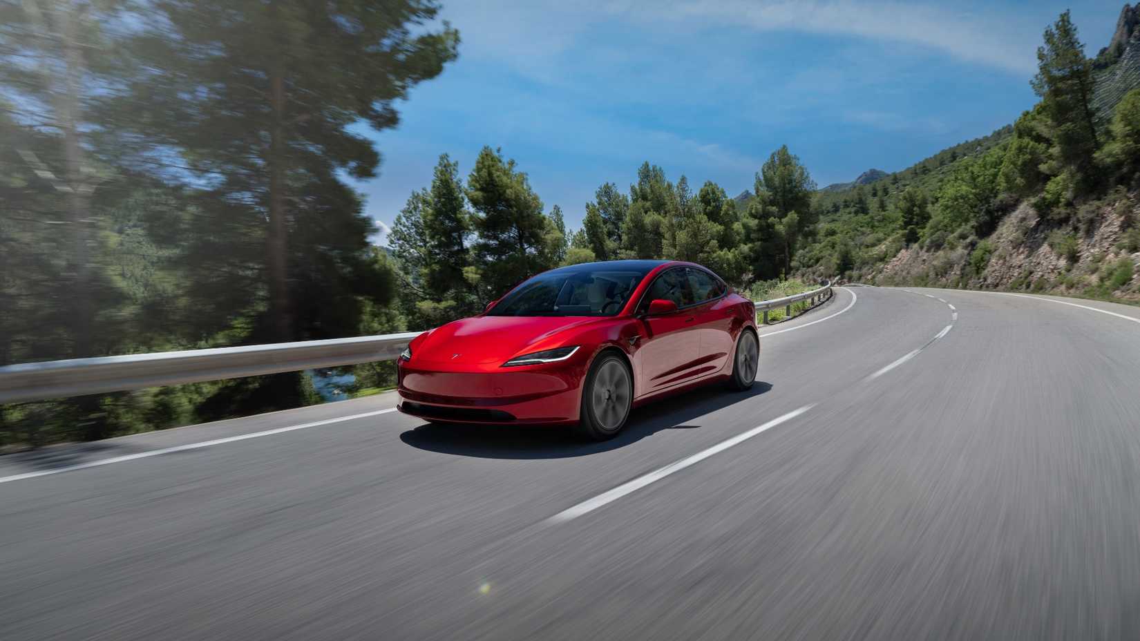 2025 Tesla Model 3 Red Front Angled View Driving