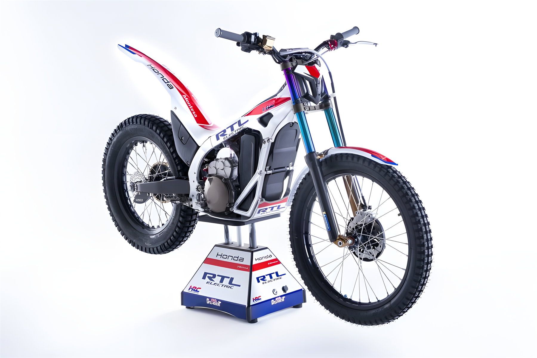 Honda RTL Electric – Dreiviertelansicht von vorne rechts im Fotostudio auf HRC-Präsentationsständer, weißes Trial-Motorrad mit rot-blauem HRC-Design, Elektromotor, USD-Gabel und Stollenreifen