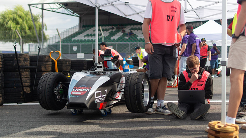 Students work on an FS-AI driverless car at Formula Student 