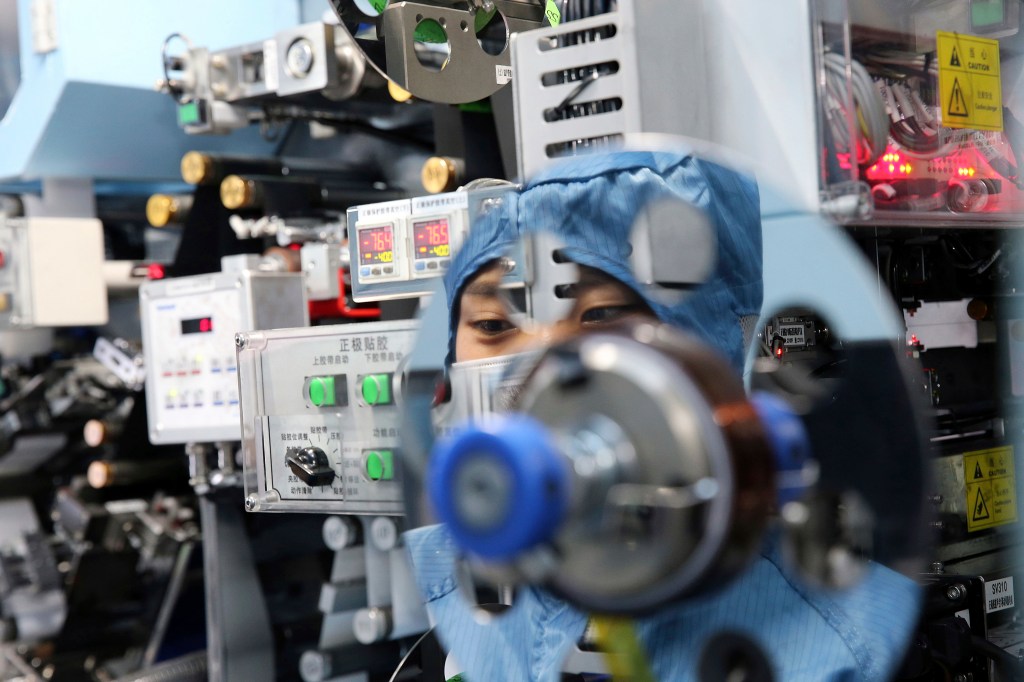 FILE - In this July 27, 2018, photo, a worker sits at a machine at a factory producing lithium-ion batteries in Taizhou in eastern China's Jiangsu Province. The U.S. government is leading an ambitious effort to develop ways to recycle lithium-ion batteries from electric vehicles, cellphones and other sources to ensure a reliable and affordable supply of metals crucial to battery production. Officials say it is an attempt to catch up with China and other countries that manufacture and recycle the vast majority of lithium-ion batteries, including those shipped back from the U.S. (Chinatopix via AP, File)