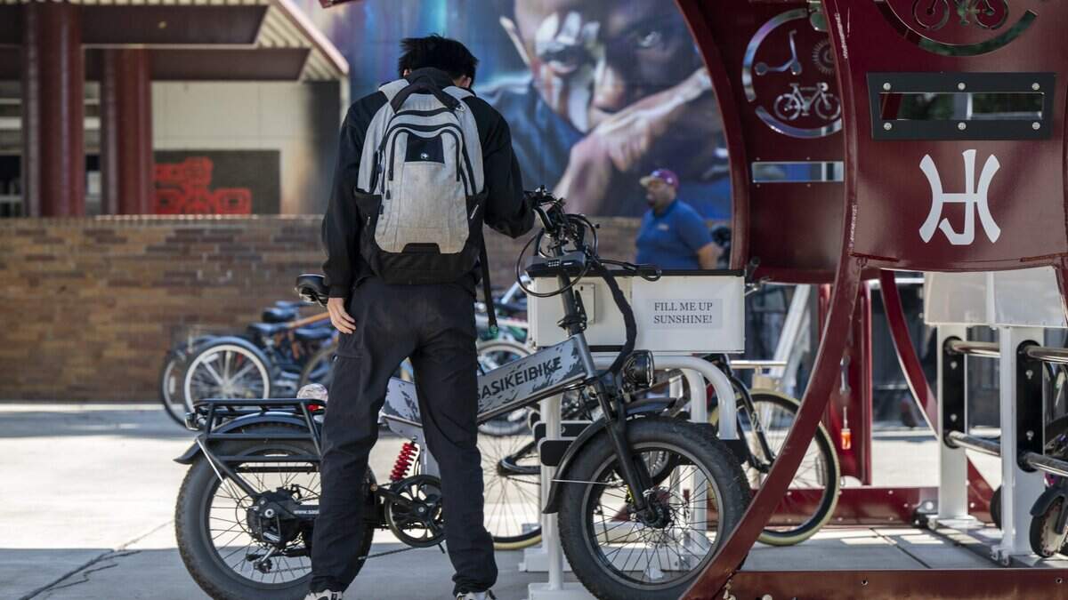Students retrieve their e-bike at the charging station after the final bell at Hiram Johnson High School in Sacramento on Wednesday, August. 12, 2026.