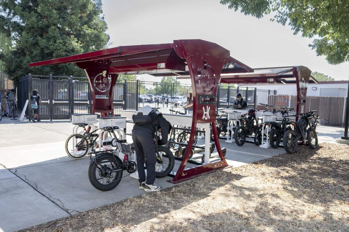 Students retrieve their e-bikes at the charging station at Hiram Johnson High School in Sacramento after the final bell on Wednesday, Aug. 12, 2026.