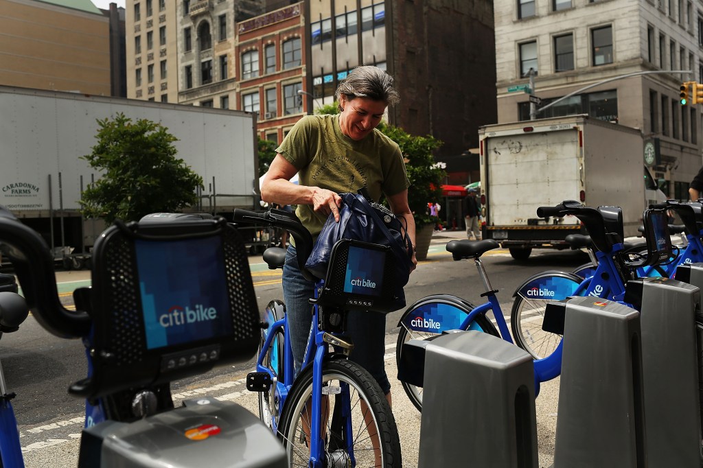 A woman returning a Citi Bike to a docking station in Union Square.